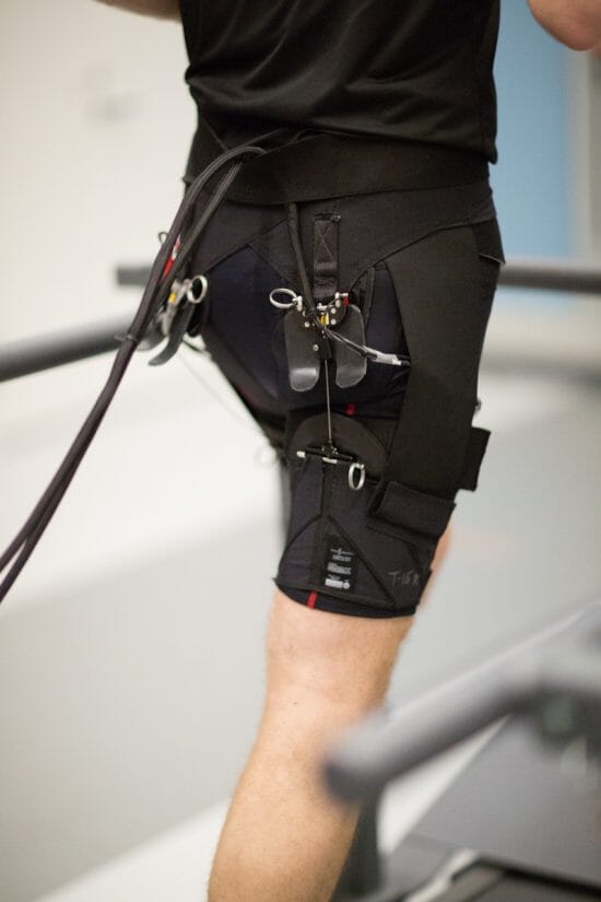 Picture of a man running with the assistance of a soft exosuit developed by The Wyss Institute at Harvard
