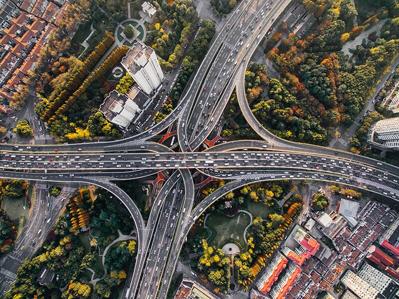 Overhead shot of a large 4-way highway intersection with busy traffic