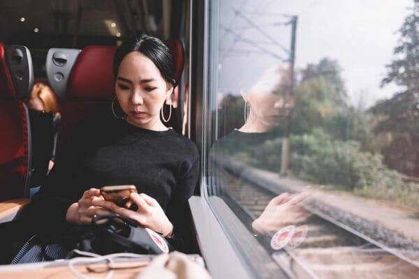asian-woman-using-mobile-phone-on-the-train-while-traveling_t20_P3PJYR