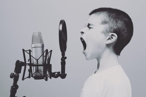 Little boy yelling into microphone